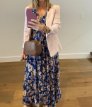 Chic floral midi dress styled with a pink blazer and crossbody bag. A woman taking a mirror selfie, wearing a blue floral midi dress, light pink blazer, and brown crossbody bag.