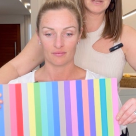 Personal colour analysis session with vibrant swatches. A woman holding colourful fabric swatches for a colour analysis session with a stylist assisting behind her.