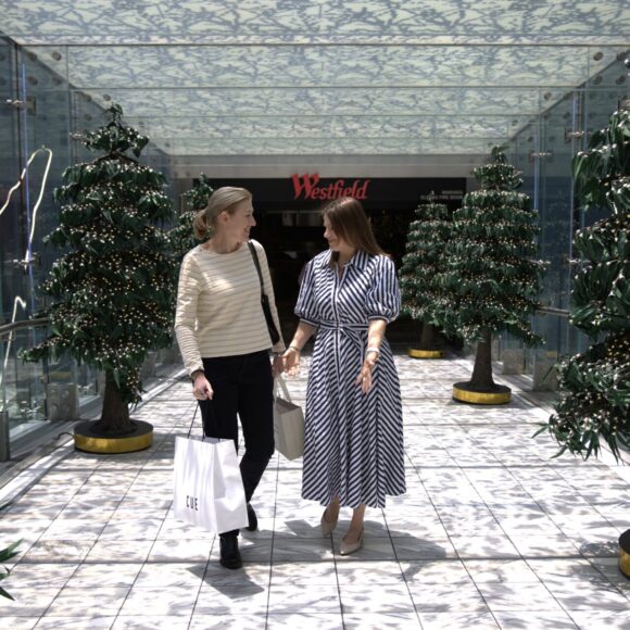 Two women walking out of Westfield shopping centre with shopping bags after a personal styling session